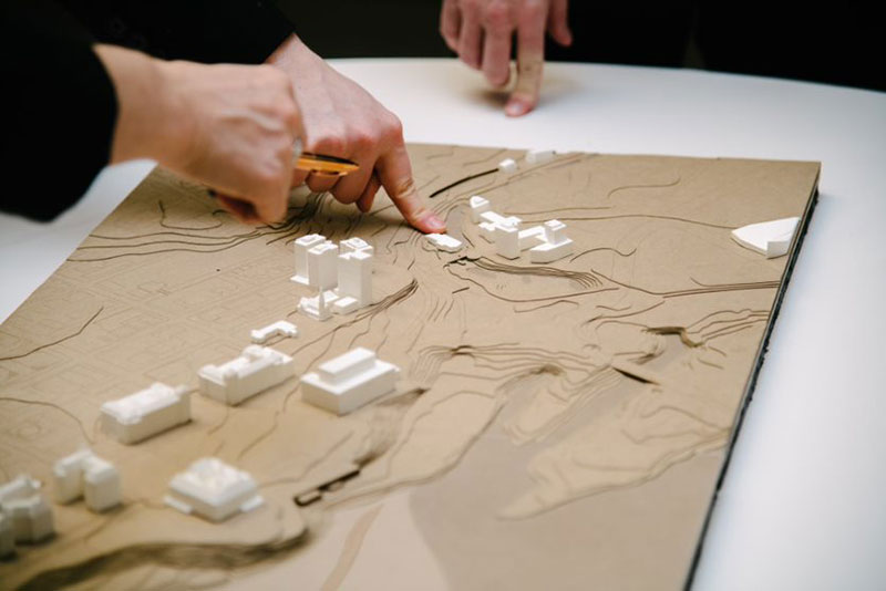 participants pointing at a topographical map of ottawa on table